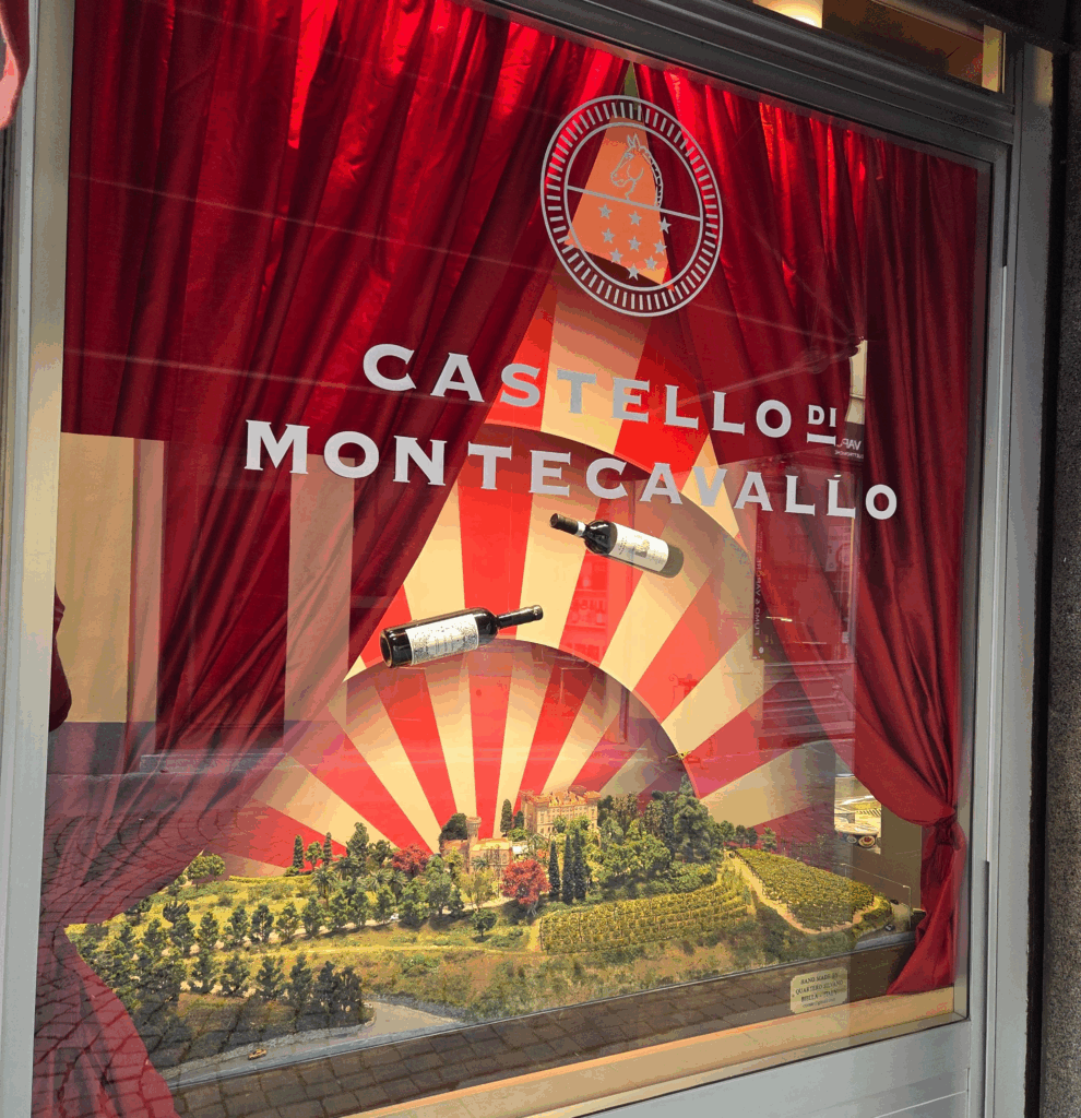 un plastico di un castello, bottiglie di vino sospese nell’aria, un allestimento teatrale che cattura l’attenzione dei passanti: è la nuova vetrina di MOSCA1916